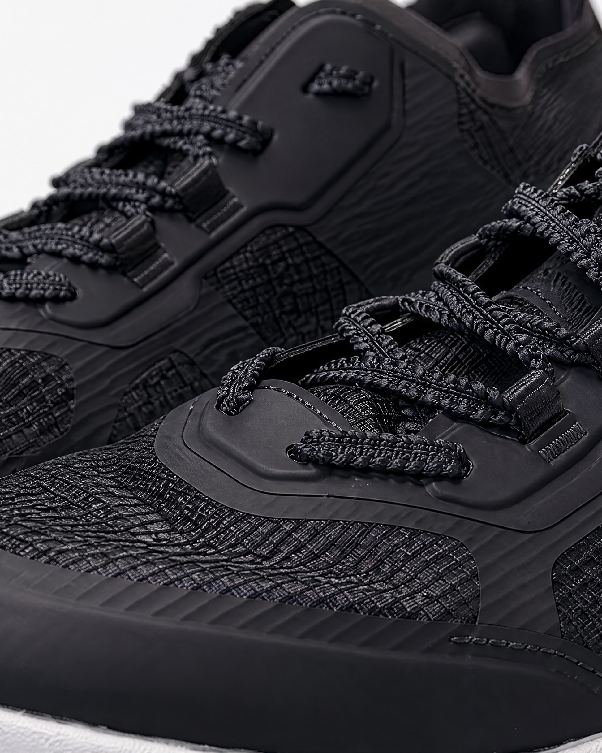 Close-up of SLAM CREW SHOES in black, featuring textured uppers, thick patterned laces, and synthetic overlays with detailed stitching—perfect for crew or uniform footwear needs.