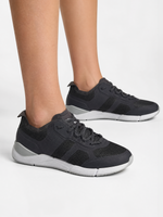 A person wearing SLAM CREW SHOES in DARK TITANIUM with white soles stands on a plain white background, showing only their lower legs and feet.