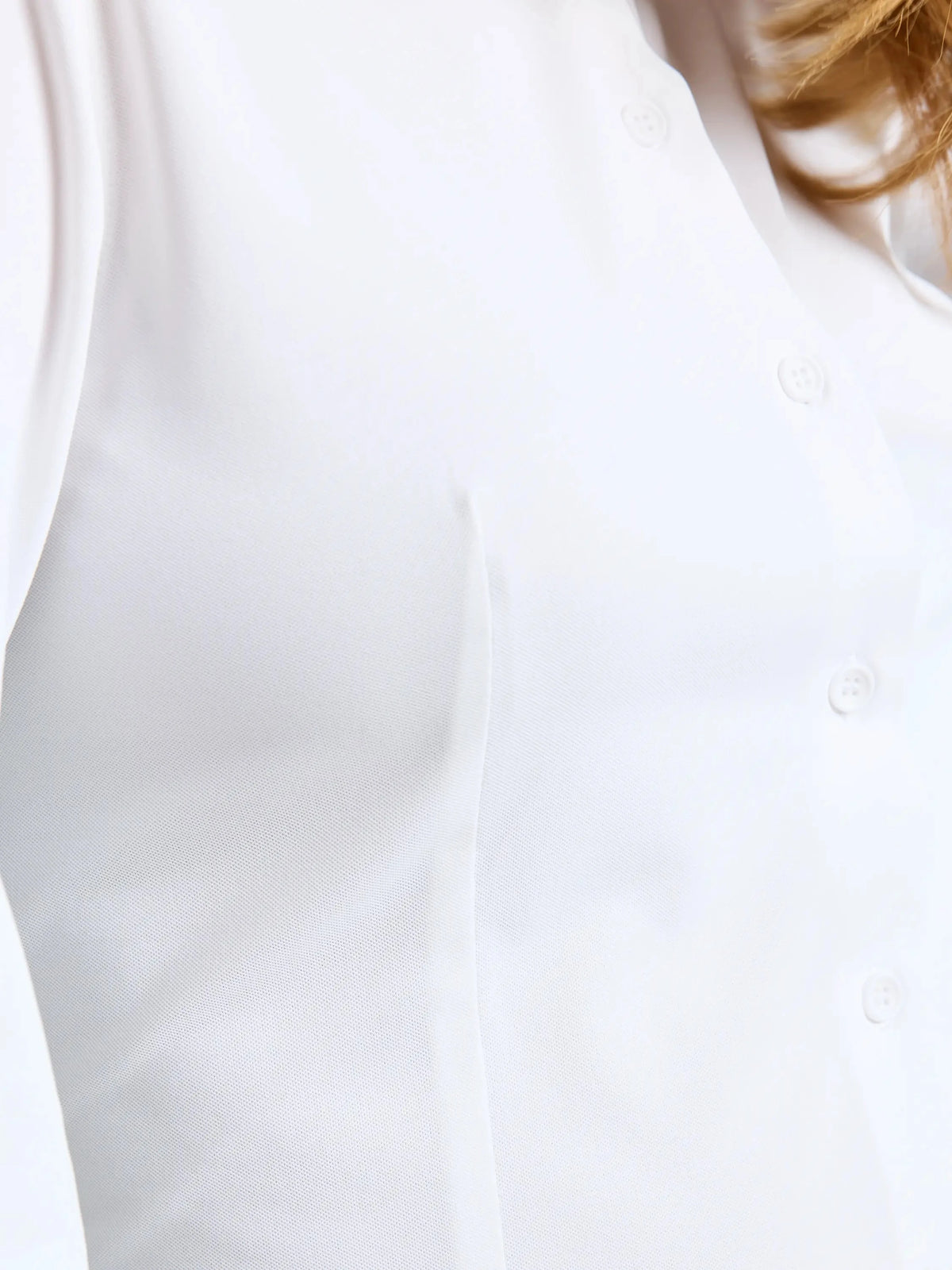 Close-up of a person wearing the SLAM WS TECH PIQUE SHIRT LS, a white, smooth and fitted long-sleeve technical shirt with visible seams and buttons that offers UPF 50+ sun protection. Part of the person’s neck and hair appears in the upper right corner of the image.
