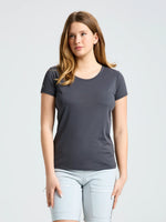 A person with long, light brown hair is wearing a SLAM WS TECH PIQUE T-SHIRT in dark gray and light gray shorts, standing against a plain light background.