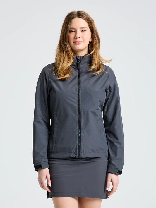 A woman faces forward against a plain light background, wearing the SLAM WS SAILING JACKET in titanium over a matching gray skirt.