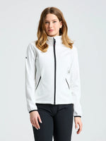 A woman with medium-length light brown hair wears the SLAM ACT WS SOFTSHELL JACKET with black zippers and black pants, standing against a plain light gray background.