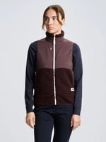 A person wearing the SLAM ALTURA WS VEST in cherry burgundy over a long-sleeve navy shirt and navy pants stands facing forward with a neutral expression against a plain light background.