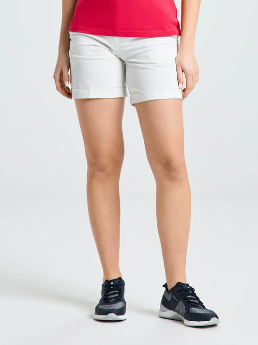 A person models the SLAM DECK WS LGT CHINO SHORT in off white, paired with black athletic shoes with white soles. Only the lower half of the body is visible against a plain light background.