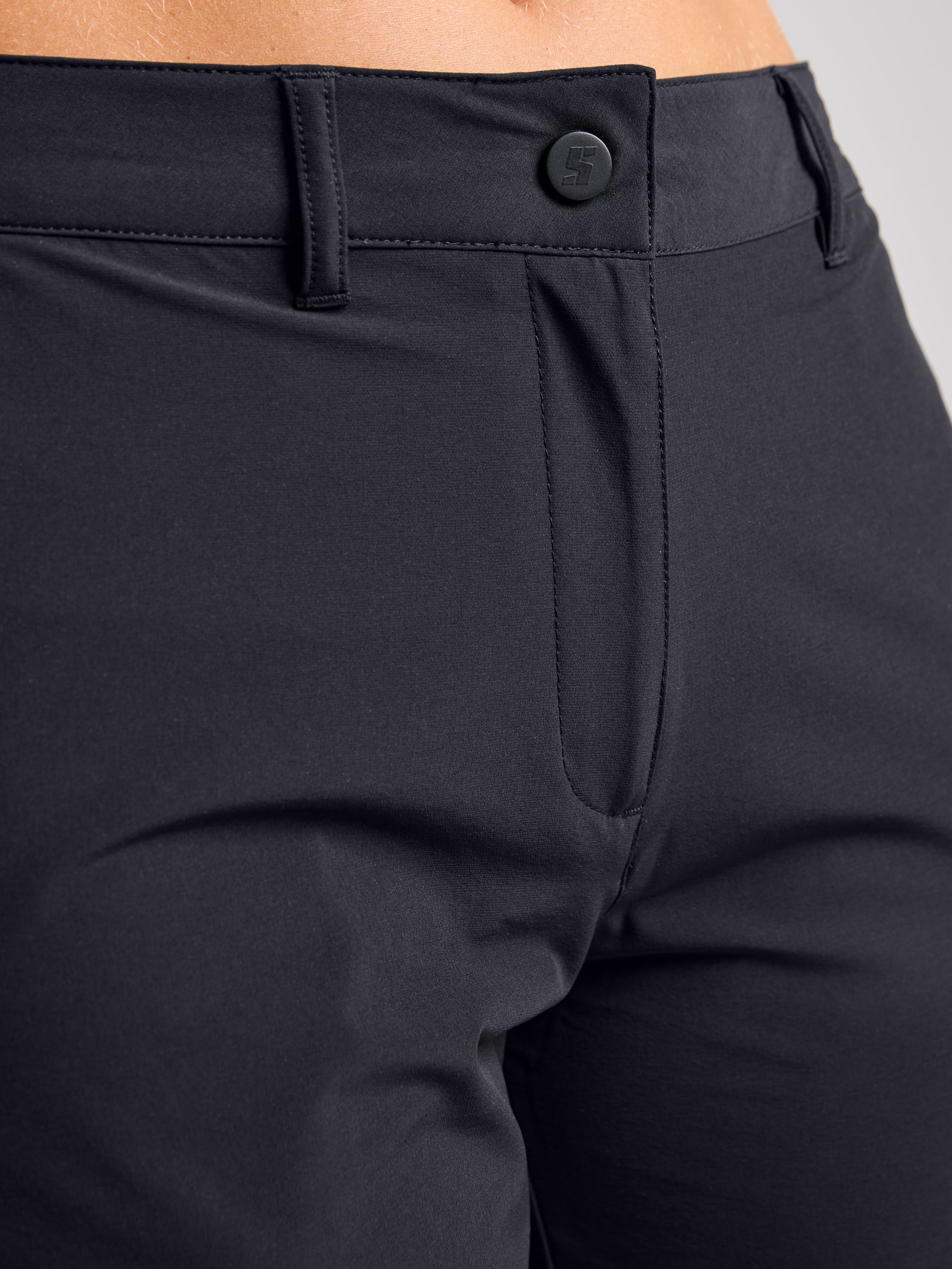Close-up of the front of a person wearing SLAM WS TECH CHINO SHORT, featuring quick-drying technical elastic fabric with waistband, belt loops, button, zipper area, and part of the upper thigh visible.