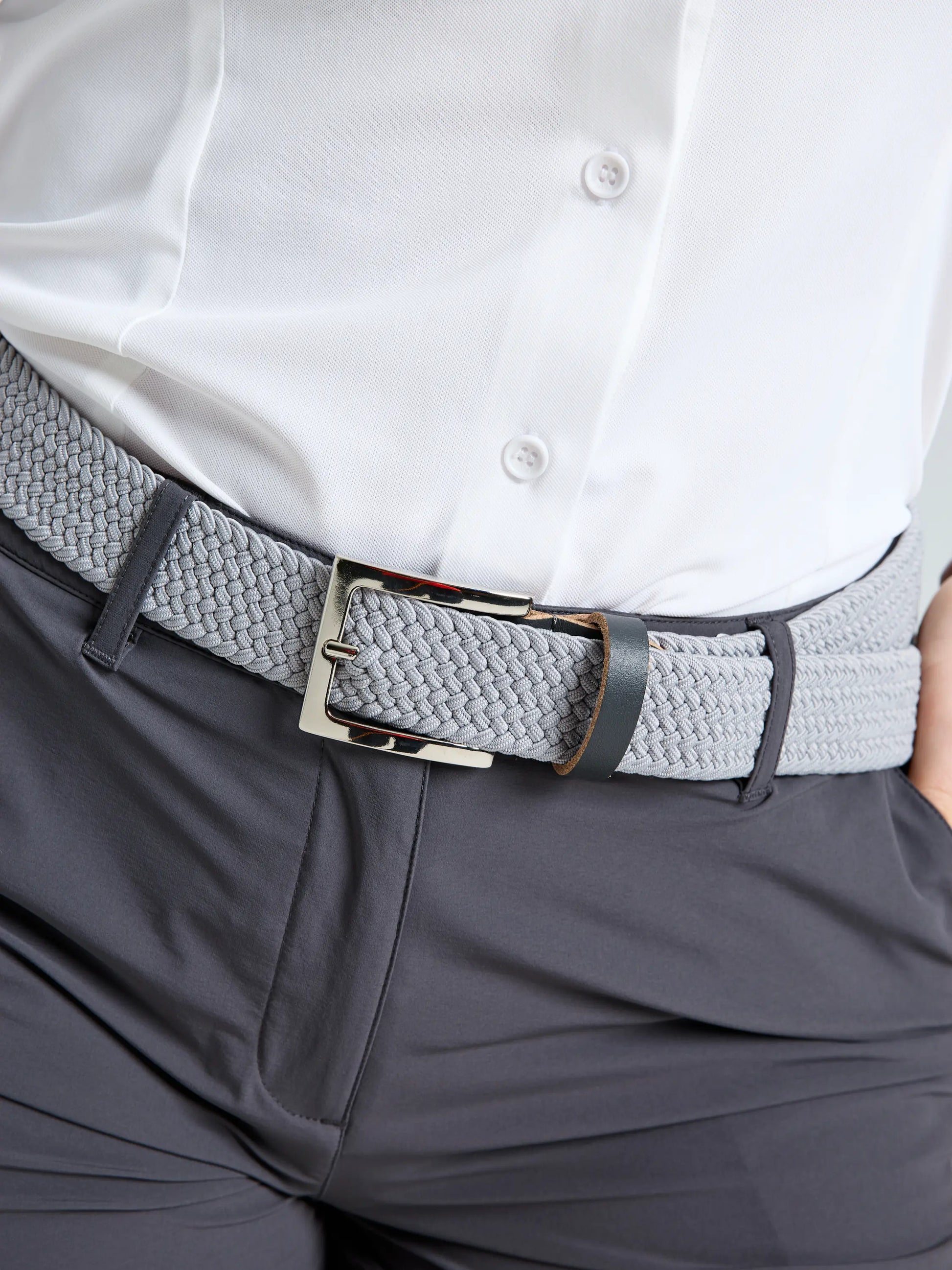 A person wearing a white button-up shirt tucked into SLAM WS TECH CHINO SHORT dark gray women's Bermuda shorts, paired with a light gray woven belt with a silver buckle.