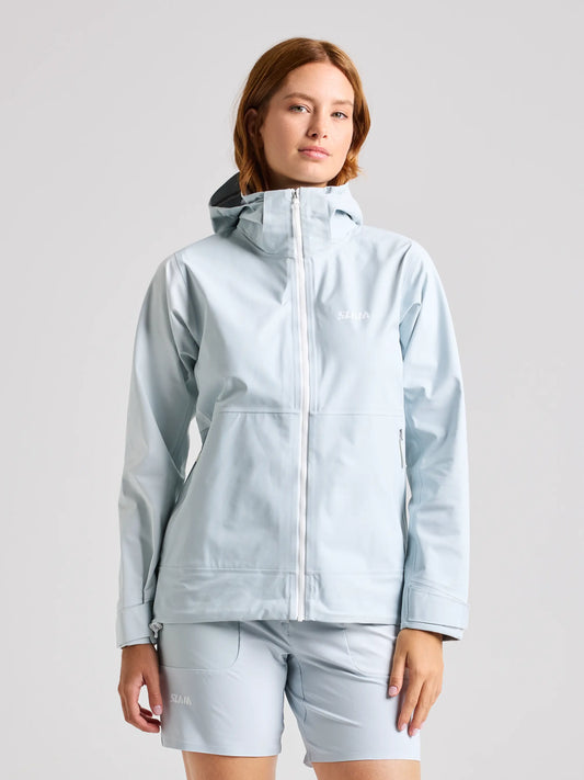 A person stands against a plain background wearing a CLIFF GREY FOIL WS HOODED JACKET by SLAM and matching shorts. The waterproof jacket is zipped up, with the person's hands relaxed by their sides.