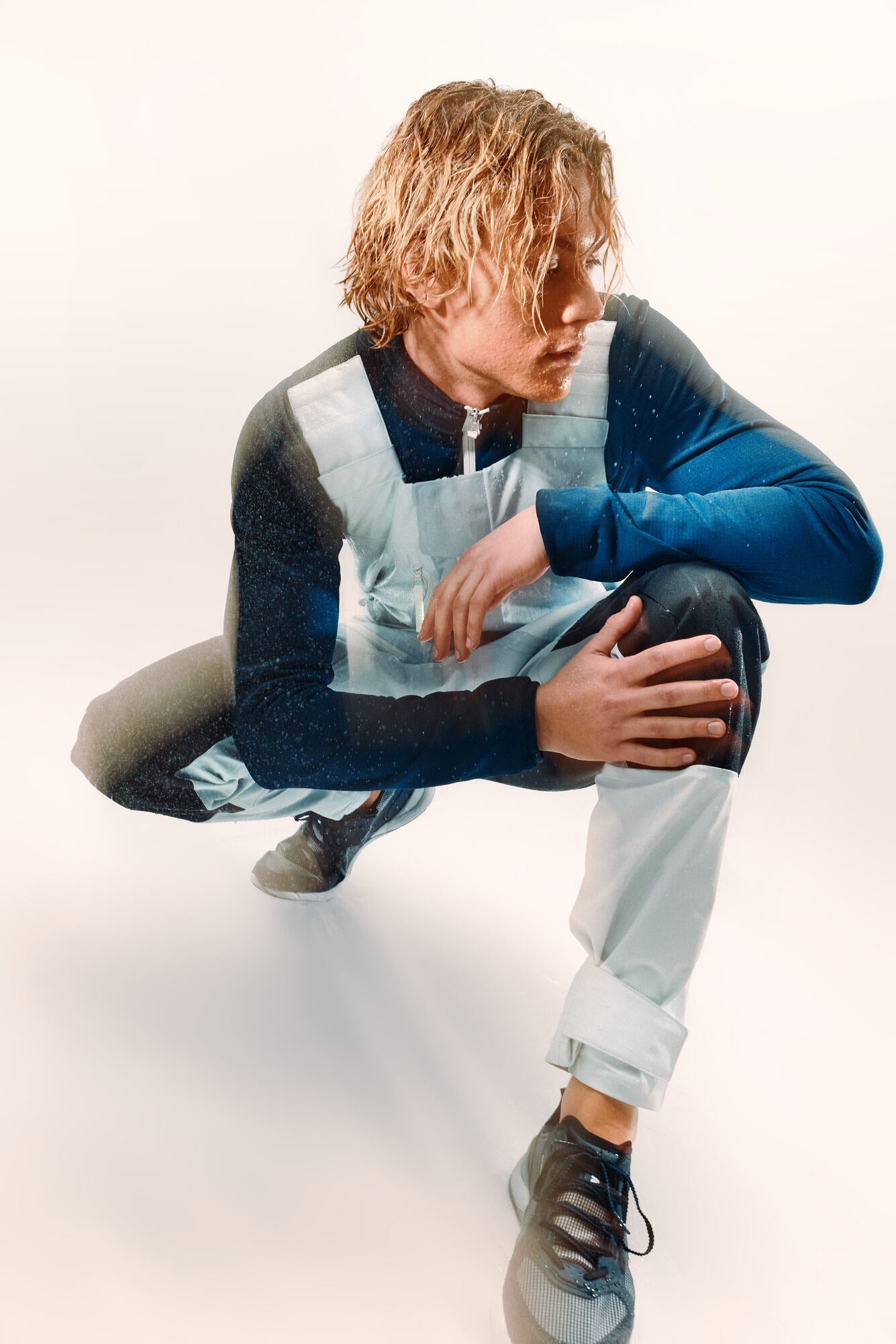 Blonde man wearing a grey long john and kneeling