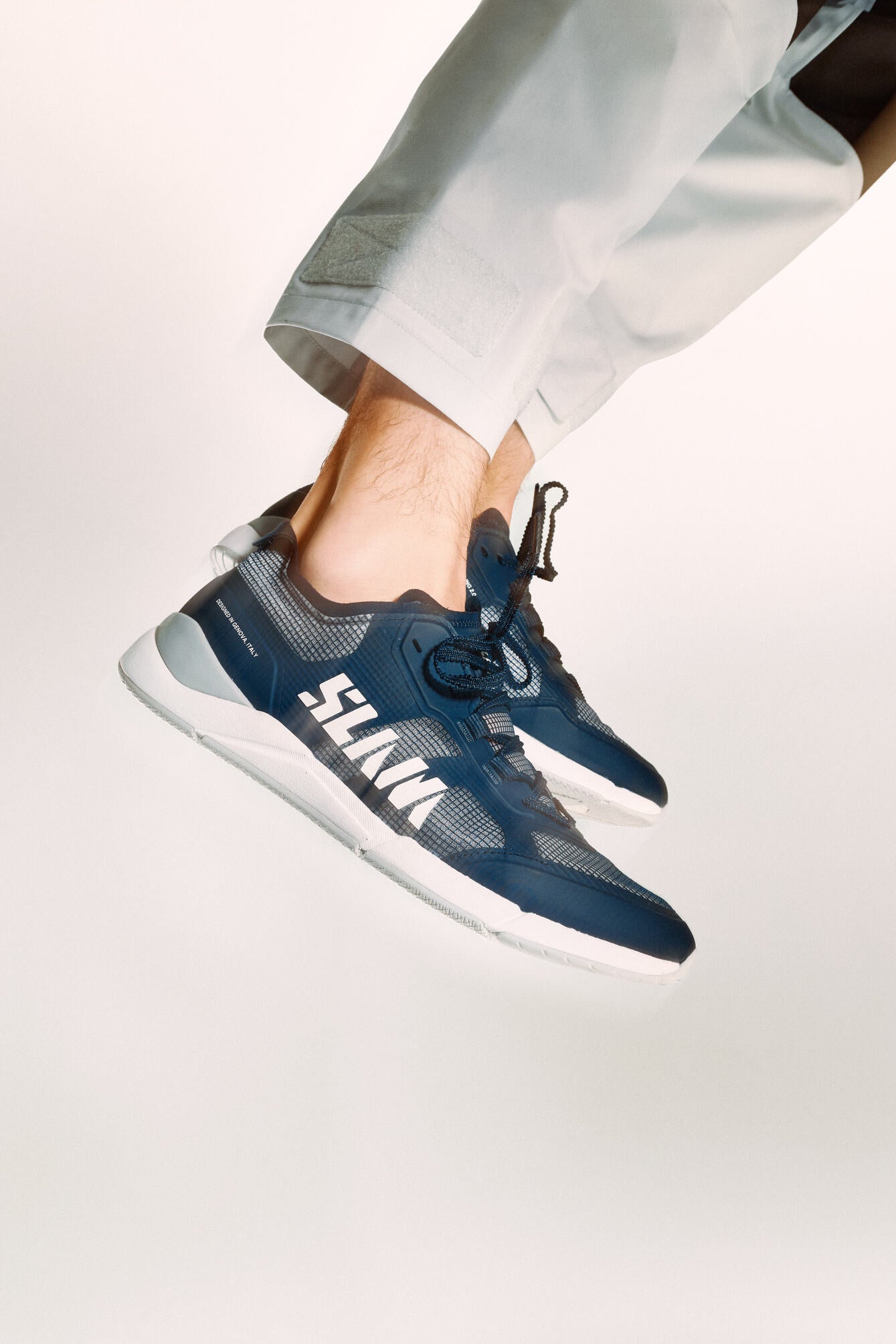 Feet flying while wearing blue trainers realized in a very lightweight fabric 